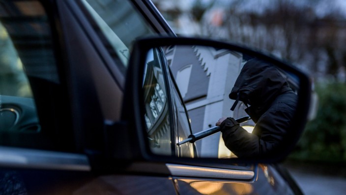 Kriminalität: Ein Mann versucht eine Autotür mit einer Metallstange aufzubrechen (gestellte Szene).