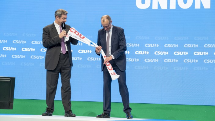 CSU-Parteitag: Freundschaftsbeweis à la Union: Markus Söder überreicht Friedrich Merz eine Art Souvenir.