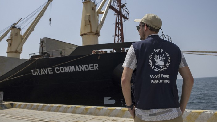 Krieg in der Ukraine: Ein Mitarbeiter des Welternährungsprogramms (WFP) im Hafen von Dschibuti neben dem Frachter "Brave Commander".