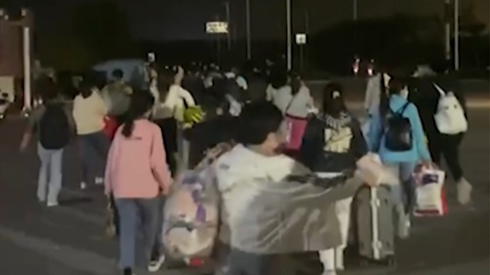 China: Der Ausschnitt dieses Videos, aufgenommen von Hangpai Xingyang, zeigt Menschen mit Koffern und Taschen, die das Firmengelände von Foxconn in Zhengzhou verlassen.