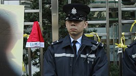 China: Liu Xiaobo verurteilt: Polizisten in Peking neben einem Plakat, das den prominenten Bürgerrechtler Liu Xiaobo zeigt: Das Verfahren gegen den 53-Jährigen fand unter strengen Sicherheitsvorkehrungen statt.
