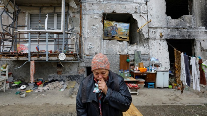 Krieg in der Ukraine: Eine Ukrainerin, die in ihr zerstörtes Wohnhaus in Mariupol zurückgekehrt ist.