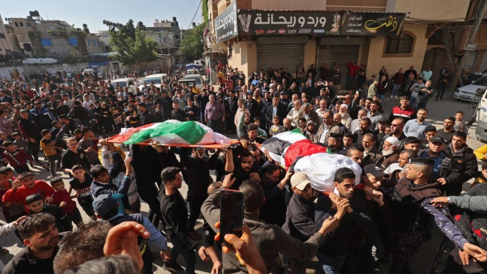 Feuer im Flüchtlingslager: Am Tag nach der Brandkatastrophe tragen Palästinenser die in Flaggen gehüllten Leichname der Opfer durch die Straßen.