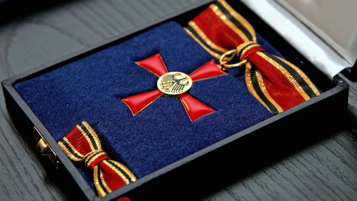 Bundesverdienstkreuz: Kupferlegierung mit Goldbeschichtung und Kunstemaille, hergestellt in Lüdenscheid: das Bundesverdienstkreuz am Bande, hier in der Ausführung für Damen.