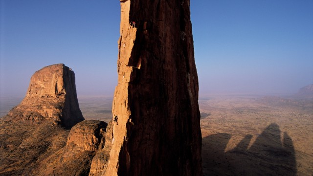 Reisebuch "Bilder aus einer Welt der Extreme": Die Hand der Fatima heißt diese Sandstein-Felsformation in Mali. Jimmy Chin hat Kevin Thaw und Cedar Wright auf einer Expedition begleitet, bei der sie alle Türme, die ihre Schatten in den Wüstensand werfen, bestiegen haben.