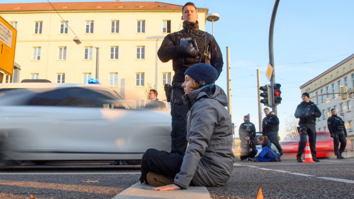 Klimaproteste: Hohe Genervtheit im Land: Eine Klimaaktivistin der "Letzten Generation" bei einer Straßenblockade in Magdeburg.