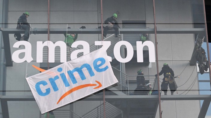Protest von Umweltschützern: Aktivisten von Greenpeace seilen sich in München am Gebäude des Online-Versandhändlers Amazon ab und bringen Transparente an.