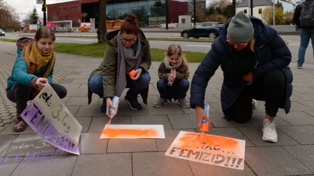 Gewalt gegen Frauen: Zum Drüberstolpern: Aktivistinnen am Freitagnachmittag auf dem Gehweg vor dem Unterföhringer Rathaus beim Aufbringen der Parolen mit Sprühkreide.