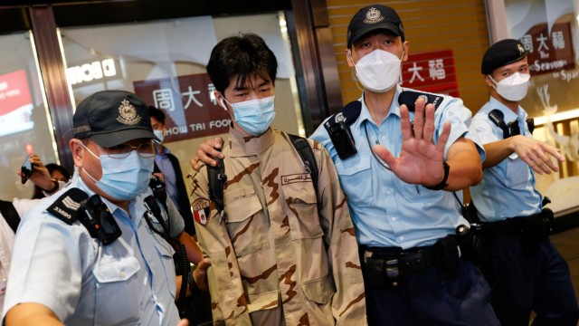 China: Ein Mann wird von der Polizei abgeführt.