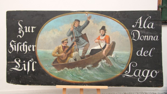 Bayerischer Mythos: Das Wirtshausschild "Zur Fischer Lisl - Ala Donna del Lago" von 1822 (Tempera auf Holz) zeigt die Fischerlisl, wie sie zwei junge Männer übers Wasser setzt.