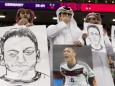 AL KHOR, QATAR - NOVEMBER 27: People in the stands hold portraits of German football player Mesut Özil in a protest agai