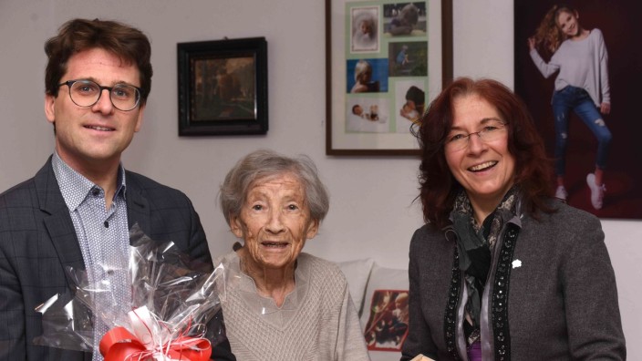 Landkreis Dachau: Gertrud Hellfritzsch feiert ihren 100. Geburtstag, auch OB Florian Hartmann und Marianne Klaffki (beide SPD) gratulieren. An der Wohnzimmerwand hängen zahlreiche Bilder ihrer Enkel und Urenkel.