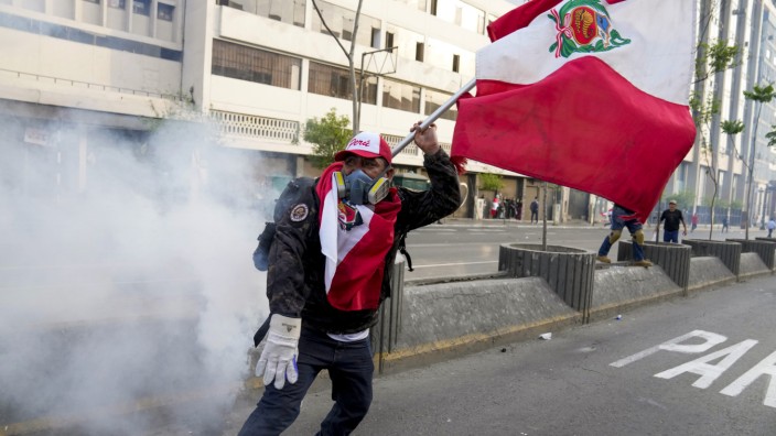 Unruhen nach Amtsenthebung: Ein Anhänger des abgesetzten Präsidenten Pedro Castillo kämpft gegen Tränengas in Perus Hauptstadt Lima.