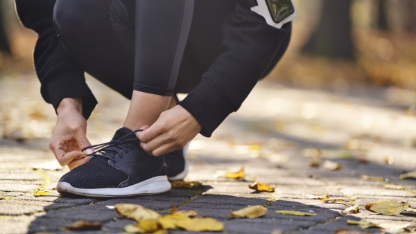 Joggen: Läufer schnürt die Laufschuhe zu