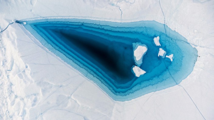 Gesellschaft: Tropfen für Tropfen: Ein Schmelzloch auf der Spitze eines Eisbergs in Westgrönland