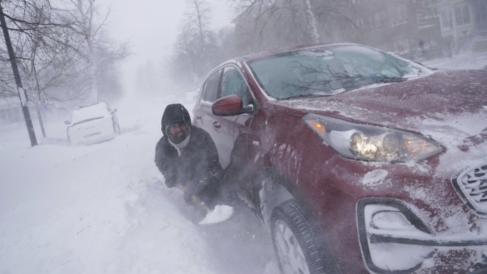 SZ am Abend: Ein Mann versucht in Buffalo sein in einer Schneewehe festgestecktes Auto auszugraben. In der Großstadt am Lake Erie fielen US-Medien zufolge mehr als 70 Zentimeter Schnee.