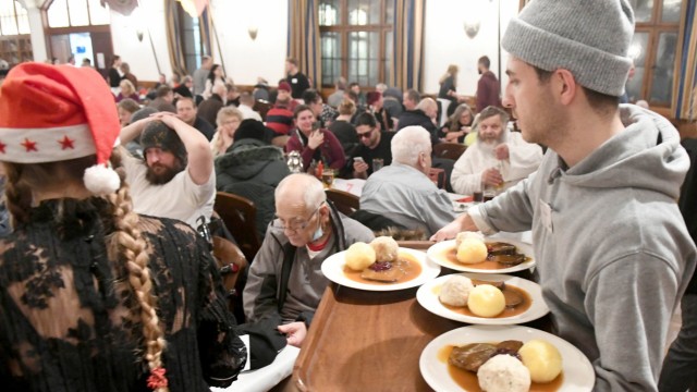SZ-Adventskalender: Ein Helfer bringt im Festsaal des Hofbräuhaus bei der Weihnachtsfeier für Wohnungslose das Essen zu den Gästen.