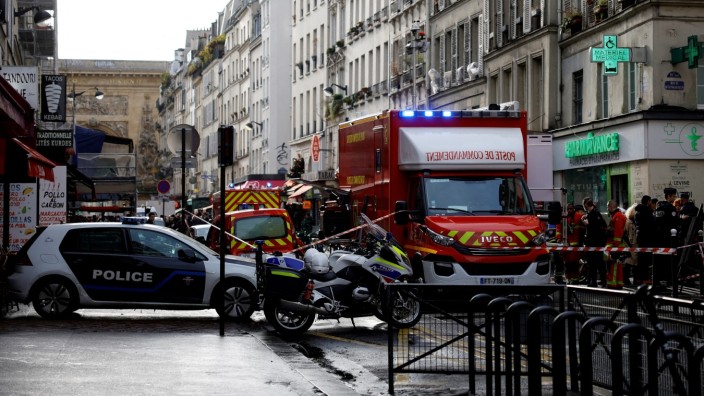 Tödliche Schüsse in Paris: Französische Polizisten und Feuerwehrleute sichern die Straße nach den tödlichen Schüssen.