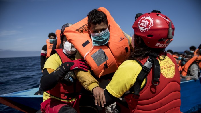 Italienisches Dekret gegen Seenotretter: Helfer der spanischen NGO Open Arms retten einen Jungen, der mit vielen anderen Flüchtlingen in einem Holzboot übers Mittelmeer gelangen wollte.