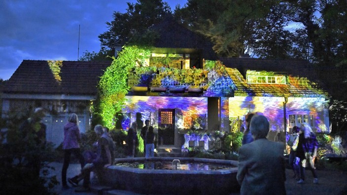 SZ-Kulturpreis Tassilo: Bei einem Lichtspaziergang in Utting zeigt Vanessa Hafenbrädl im Dezember 2022 den Besuchern das beleuchtete Künstlerhaus Gasteiger.
