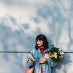 Portrait of Happy Woman Holding Flowers and Using a Mobile Phone Outdoors; alles liebe