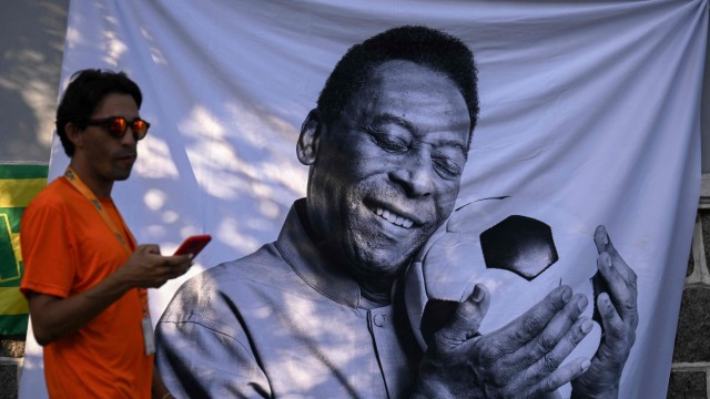 Totenwache in Brasilien: Sein Freund, der Ball: Ein Passant in Santos vor einem Porträt Pelés.