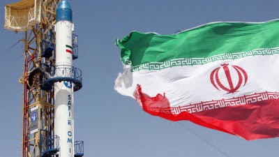 Zeitungsbericht: Eine iranische Fahne weht vor der Safir-Rakete, die Satelliten in den Orbit bringen kann.