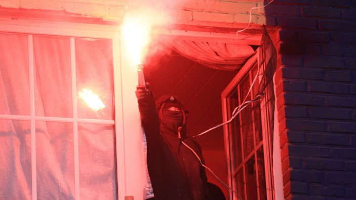 Klimaschutzbewegung: "Wir werden euch nicht mehr in Ruhe lassen": Ein Aktivist mit einer brennenden Leuchtfackel in einem der Abbruchhäuser in Lützerath.