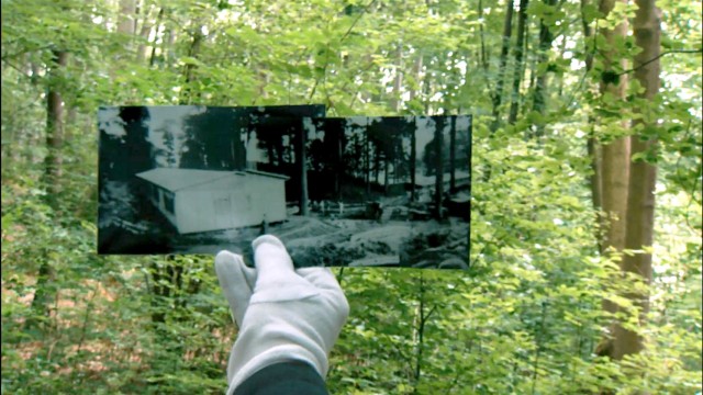 3sat-Dokumentation: Bild im Bild: Das alte Motiv einer KZ-Baracke ist unter den überwucherten Bäumen nicht mehr zu erkennen.