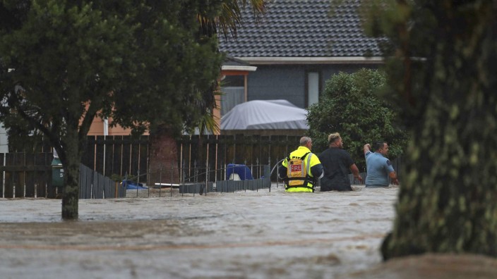 Unwetter: Rettungskräfte gehen auf einer überfluteten Straße in Neuseelands größter Stadt Auckland.