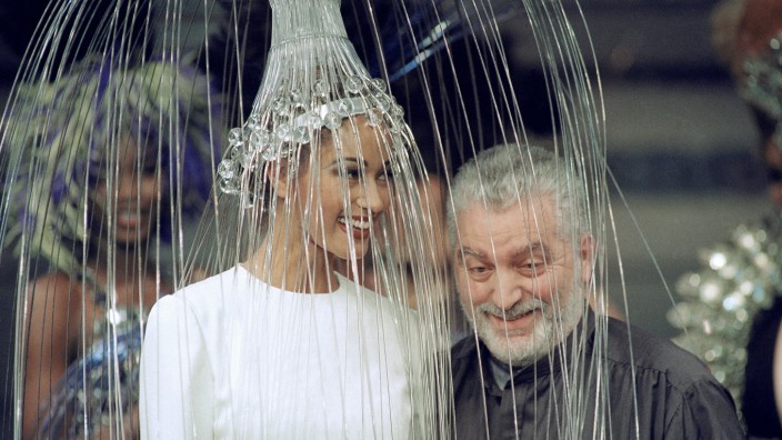 Mode: Der spanische Modedesigner Paco Rabanne zeigt sich mit einem Modell, das ein weißes Kleid mit einer metallischen Kopfbedeckung trägt, nach der Präsentation seiner Haute-Couture-Kollektion für Herbst/Winter 1992/93. Jetzt starb im Alter von 88 Jahren.