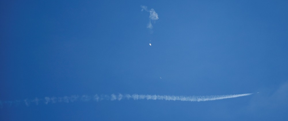 A jet flies by a suspected Chinese spy balloon after shooting it down off the coast in Surfside Beach