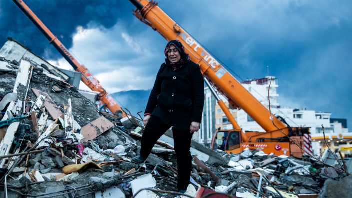 Türkei: "Bitte schickt ein Team": Eine Frau auf den Trümmern eines Hauses in Iskenderun, unter denen Familienangehörige verschüttet sind.