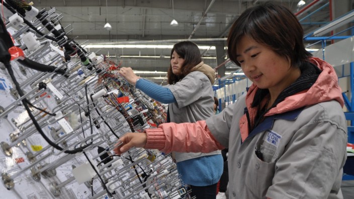 Autozulieferer: Leoni-Mitarbeiterinnen stecken Kabel in einem chinesischen Werk des Automobilzulieferers.