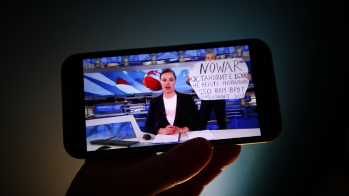 Protest gegen den Krieg in der Ukraine: "Stoppt den Krieg. Glaubt der Propaganda nicht. Hier werdet ihr belogen": Marina Owsjannikowa (im Hintergrund) mit ihrem Protestplakat im Fernsehen.