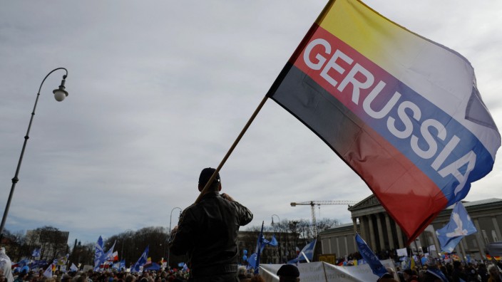 Putin-Propaganda auf Münchner Demo: "Gerussia"-Fahne mit Reichsbürger-Symbolik auf dem Münchner Königsplatz: Dahinter steckt ein in Niederbayern lebender russischer Kreml-Propagandist.