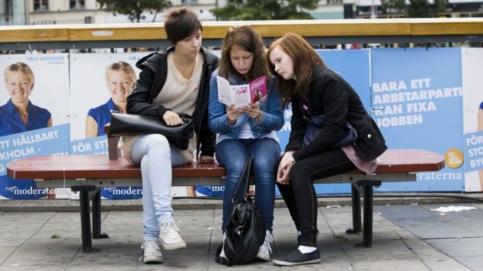 Drei Mädchen lesen 2010 in Stockholm ein Flugblatt der  Feministiskt initiativ, einer feministischen Partei.
