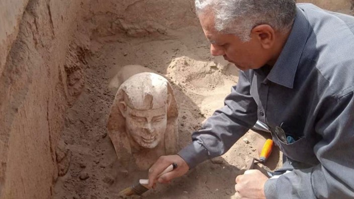 Archäologie: Ein vom ägyptischen Ministerium für Altertümer veröffentlichtes Foto zeigt einen Arbeiter, der die Sphinx-Skulptur ausgräbt.