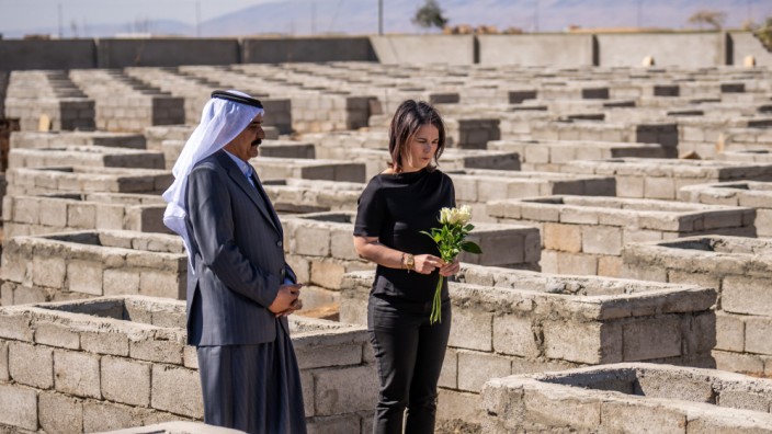 Baerbock im Irak: Annalena Baerbock legt Blumen am Friedhof von Kocho im Norden des Iraks nieder. Begleitet wird sie von Stammesführer Naif Jasim.