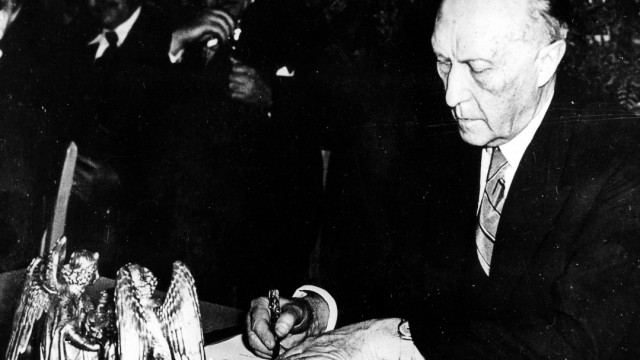 Das Politische Buch: 23. Mai 1949, 17 Uhr: Konrad Adenauer, Präsident des Parlamentarischen Rates, bei der Unterzeichnung des Grundgesetzes. Das Titenfass im Vordergrund stand nur zur Zierde da.