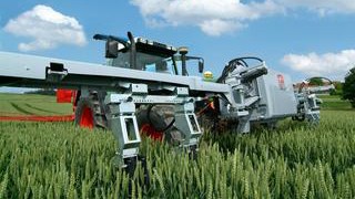Vortragsreihe TUM@Freising: Hightech in der Landwirtschaft: Ein Traktor misst in einem Weizenfeld mit Hilfe von Sensoren den Nährwert des Getreides und stimmt die Düngung darauf ab.