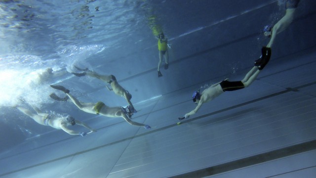 Unterwasserhockey: Von jedem Team schwimmt beim Anstoß jeweils der schnellste Spieler zum in der Mitte liegenden Puck.