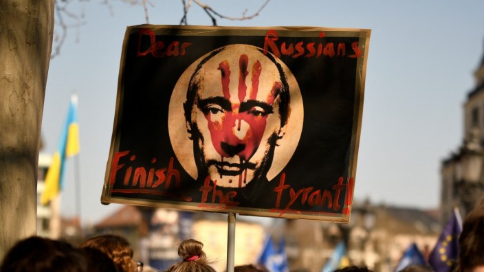 Wladimir Putin: "Stoppt den Tyrannen", steht auf diesem Plakat. Dass Wladimir Putin Blut an den Händen hat, finden nicht nur Demonstranten in Frankfurt - sondern auch die Strafverfolger aus Den Haag.