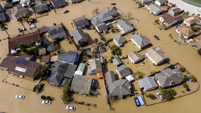 Psychologie: Deichbruch in Kalifornien: Das Wasser umspült Häuser und Fahrzeuge in der Gemeinde Pajaro in Monterey County. Was der Klimawandel damit zu tun hat? Das wollen zunehmend viele Menschen nicht so genau wissen.