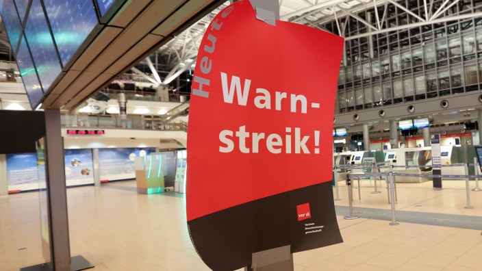 Verkehrssektor: Ein Plakat mit "Warnstreik" hängt im menschenleeren Terminal 2 im Flughafen Hamburg.