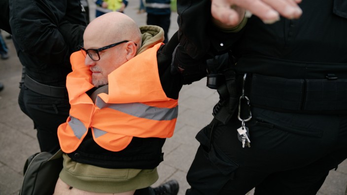 Gewalt gegen Klimaaktivisten: Auf einer Zufahrtsstraße zum Mittleren Ring in München blockieren Klimaaktivisten den Berufsverkehr. Beamte tragen einen von ihnen weg (Symbolbild)