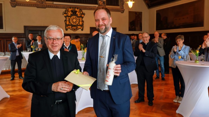 Jubiläum in Freising: Der Erzbischof von Berlin, Heiner Koch (links), überreicht dem Freisinger Oberbürgermeister Tobias Eschenbacher eine Friedenskerze.
