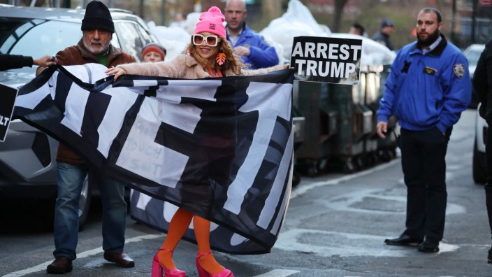 Reaktionen: Als die Anklage bekannt wird, versammeln sich einige Menschen in New York. "Verhaftet Trump" steht auf dem Schild, das diese Frau in den Händen hält.