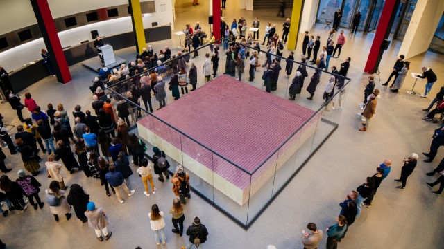 Ausstellung in der Pinakothek der Moderne: Wie ein monolithischer, bordeauxroter Block wirkt die Installation "One Million German Passports" von Alfredo Jaar in der Rotunde der Pinakothek der Moderne von der Galerie aus betrachtet.