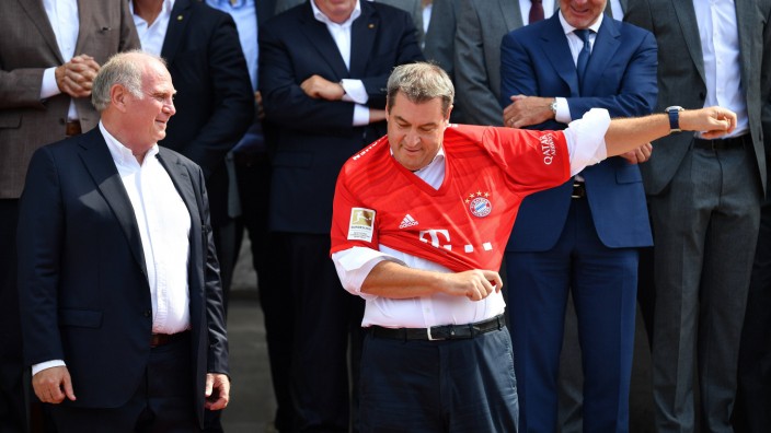 Markus Söder und der FC Bayern: Einer der Höhepunkte in der sportlichen Vita von Markus Söder: Der FC Bayern überreicht Bayerns Ministerpräsident im Mai 2019 ein Bayern-Trikot, Uli Hoeneß (links) beobachtet, ob der Franke es tragen kann.